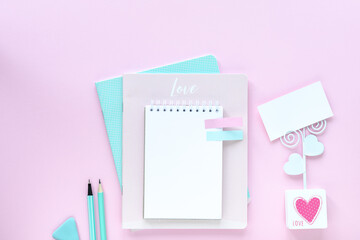 Various colorful stationery for school and office on pink background with copyspace.