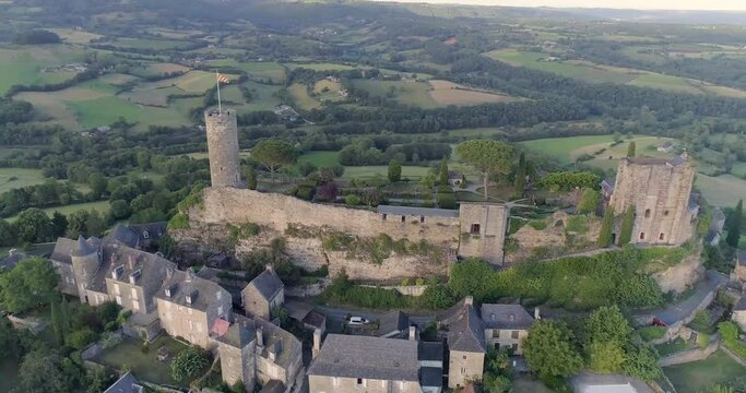 drone au dessus de Turenne en Corr&egrave;ze, cit&eacute; m&eacute;di&eacute;val avec ch&acirc;teau entour&eacute; par un petit village en France pendant le couch&eacute; du soleil avec des jardins en hauteur 