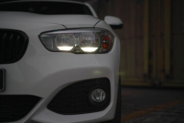 headlights of a white sports car in the dark