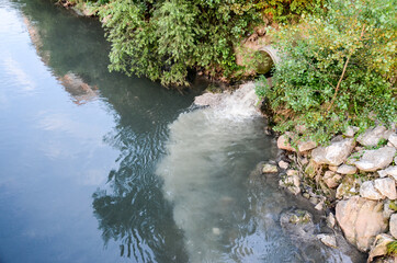 Sewage drains into the river. Environmental pollution. Ecological catastrophe and disaster. Water...