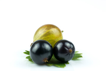 Gooseberry and two berries of black currant on a green leaf isolated on white background.