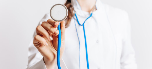 Doctor with a stethoscope in the hands on white background