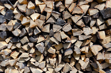 Natural sawn wood stacked in row. Firewood storage concept.  Stacks of chopped logs as background.