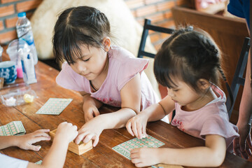 Kids playing board game at their home. Table top game is a good activity for children to learn how to play with others and improve attention and strategy thinking.