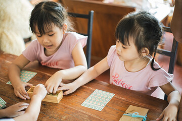 Kids playing board game at their home. Table top game is a good activity for children to learn how...
