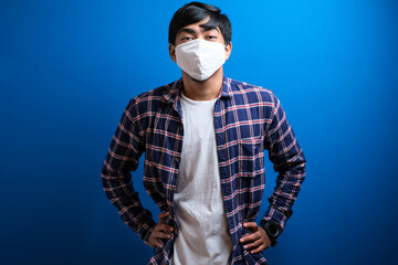 A young asian student wearing a medical face mask that protects against the spread of corona virus...