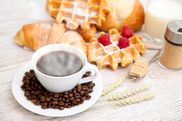 Breakfast in the morning with black coffee cup with bread with Croissant and fruit on the wooden table.