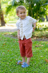 Young adorable little boy with blond hair at the park outdoors