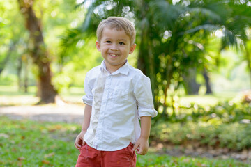 Young adorable little boy with blond hair at the park outdoors