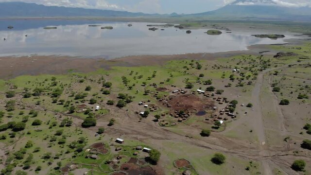 Aerial Flyby View on the Maasai village in on the coast of Natron Lake front of the Ol Doinyo Lengai, Mountain of God in the Maasai language, Engare Sero village in Arusha Region i the Northern