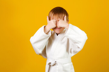 Child wearing white kimono. Happy karate kid. Healthy sporty childhood. Martial arts school.