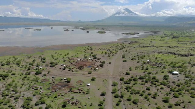 Aerial Flyby View on the Maasai village in on the coast of Natron Lake front of the Ol Doinyo Lengai, Mountain of God in the Maasai language, Engare Sero village in Arusha Region i the Northern