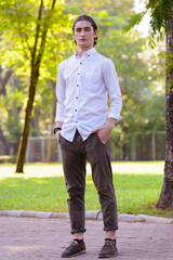 Full body shot of young handsome businessman at the park outdoors