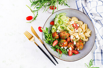 Italian pasta. Conchiglie with meatballs, feta cheese and salad on light background. Dinner. Top view, overhead. Slow food concept
