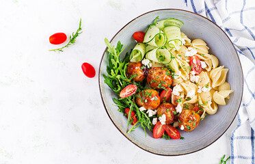 Italian pasta. Conchiglie with meatballs, feta cheese and salad on light background. Dinner. Top view, overhead. Slow food concept