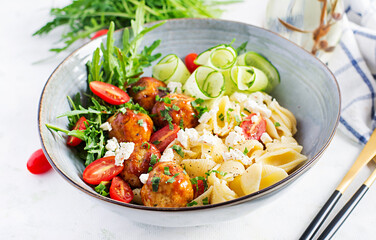 Italian pasta. Conchiglie with meatballs, feta cheese and salad on light background. Dinner. Slow food concept