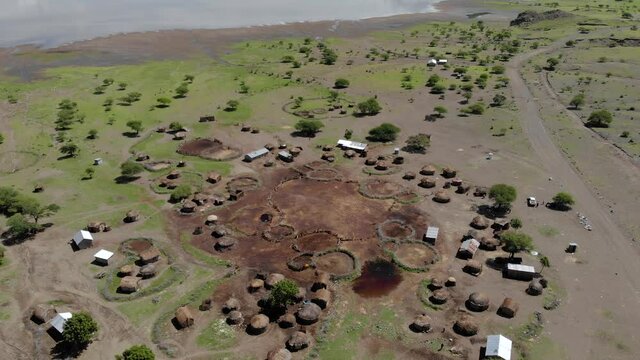 Aerial Flyby View on the Maasai village in on the coast of Natron Lake front of the Ol Doinyo Lengai, Mountain of God in the Maasai language, Engare Sero village in Arusha Region i the Northern