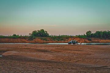 Obraz premium the family arrived in an SUV to relax on the sandy river bank