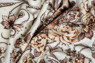 top view closeup on crumpled milk cotton scarf with colorful floral ornament