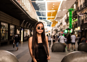 Young hispanic woman posing on a summer day while strolling through a square