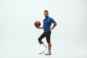 Athlete with disabilities or amputee on white studio background. Professional male basketball...