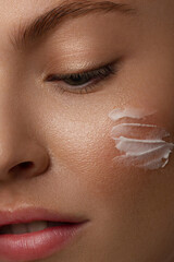 Close up of the face of a beautiful woman with perfect skin thanks to creams to keep young and cream contour anti-aging and wrinkle eyes. Concept of beauty, cleanliness and perfection