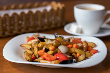 Pan-Asian dish: pork with eggplant, carrots, peppers, potatoes and onions in a sweet and sour sauce. Street cafe in the city.