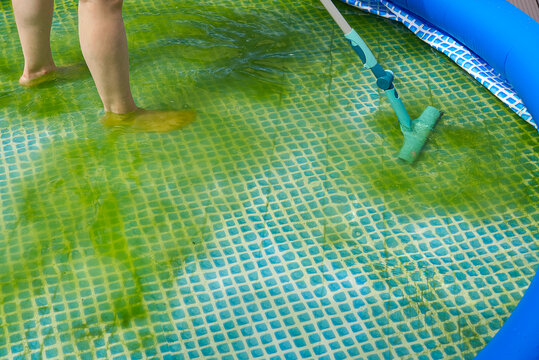 Cleaning pvc inflatable swimming pool, Cleaning the dirty empty pool of algae, The beginning of the swimming season in the hot summer. Cleaning service concept.