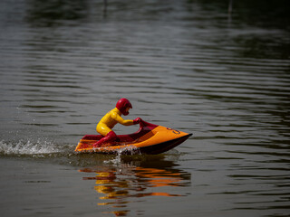 RC controlled jet ski model on lake. Active summer vacation for school child.