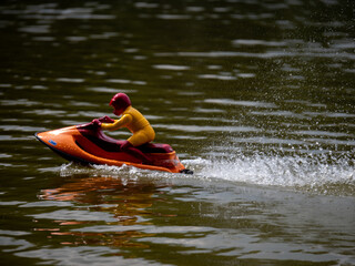 RC controlled jet ski model on lake. Active summer vacation for school child.