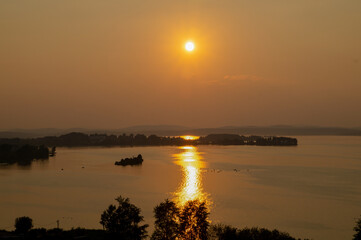 The sun sets over the city pond. Pond at sunset with sun glare