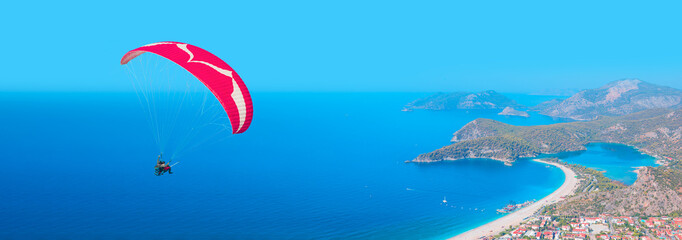 Paraglider flies in the sky - Panoramic view of amazing Oludeniz Beach And Blue Lagoon, Oludeniz...