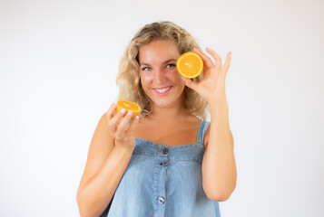 Pretty blonde woman in blue dress smiling with an orange in the eye