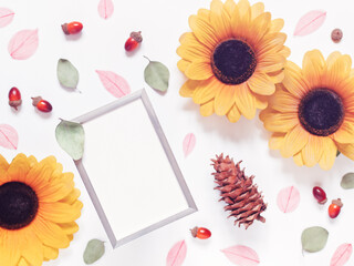 Autumn composition. Template made from blank metal photo frame, dried leaves, cones, flowers and acorns. Flat lay. Top view. Copy space.
