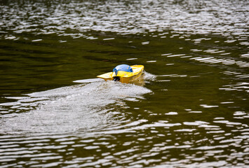 RC controlled jet boat model on lake. Active summer vacation for school child.