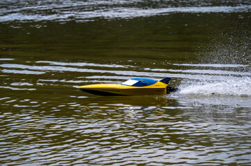 RC controlled jet boat model on lake. Active summer vacation for school child.