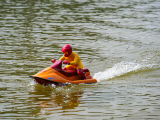 RC controlled jet ski model on lake.