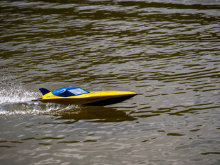 RC controlled speedboat model on lake. Active summer vacation for school child.