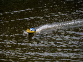 RC controlled speedboat model on lake. Active summer vacation for school child.