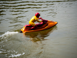 RC controlled jet ski model on lake.