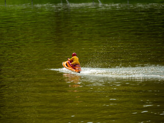 RC controlled jet ski model on lake.