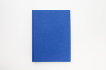 Blue book with no title standing on white background