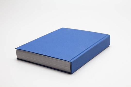 Blue book with no title standing on white background