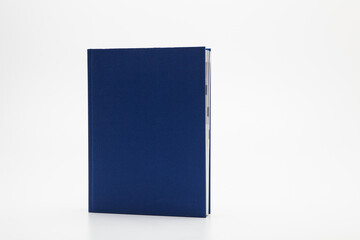 Blue book with no title standing on white background