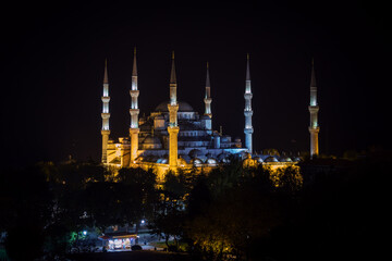 Fototapeta na wymiar View of six minaret Blue Mosque of Ottoman architecture illuminated by night in Istanbul, Turkey