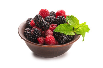 Raspberry, blackberry and mint leaf in ceramic brown bowl isolated on white