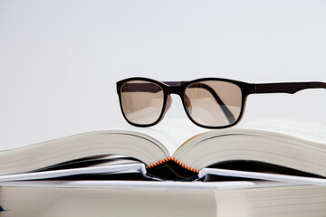 Open book and glasses on white background