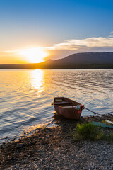 fishing boat on the shore during sunset