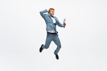Fototapeta na wymiar Winner, jump. Man in office clothes running, jogging on white background like professional athlete, sportsman. Unusual look for businessman in motion, action with ball. Sport, healthy lifestyle