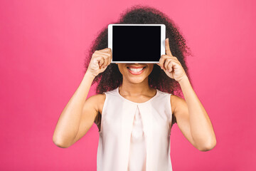 Smiling afro american young student woman showing blank tablet computer isolated over pink...